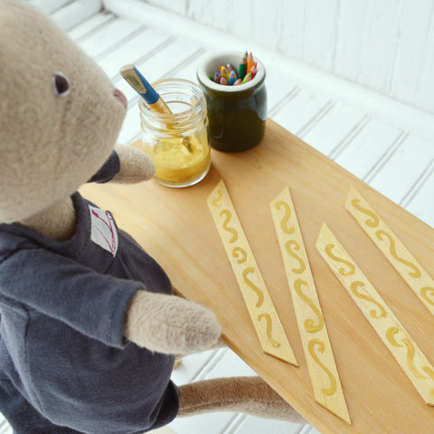Juliette Rabbit paints wood sticks for picture frames