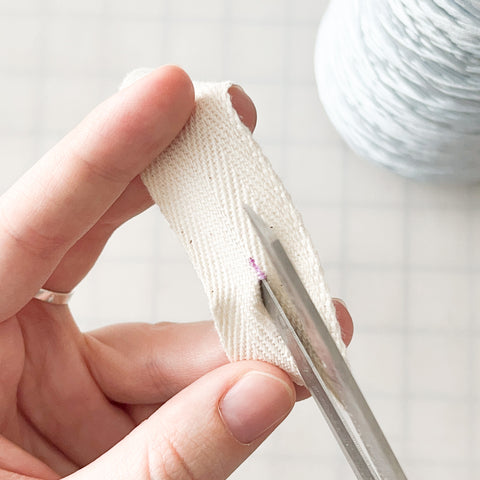 scissors cutting the buttonhole slit the rest of the way