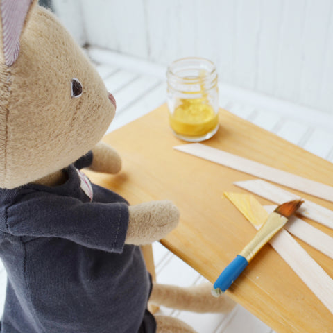Juliette Rabbit paints wood sticks for picture frames